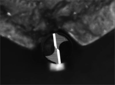 Source blue-ring capture showing the small circular bit face, darker shaped regions and a bright central strip.